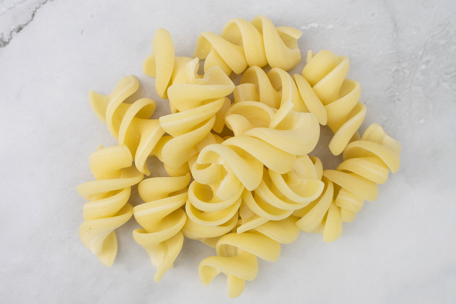 Fusiloni pasta on white marble bench